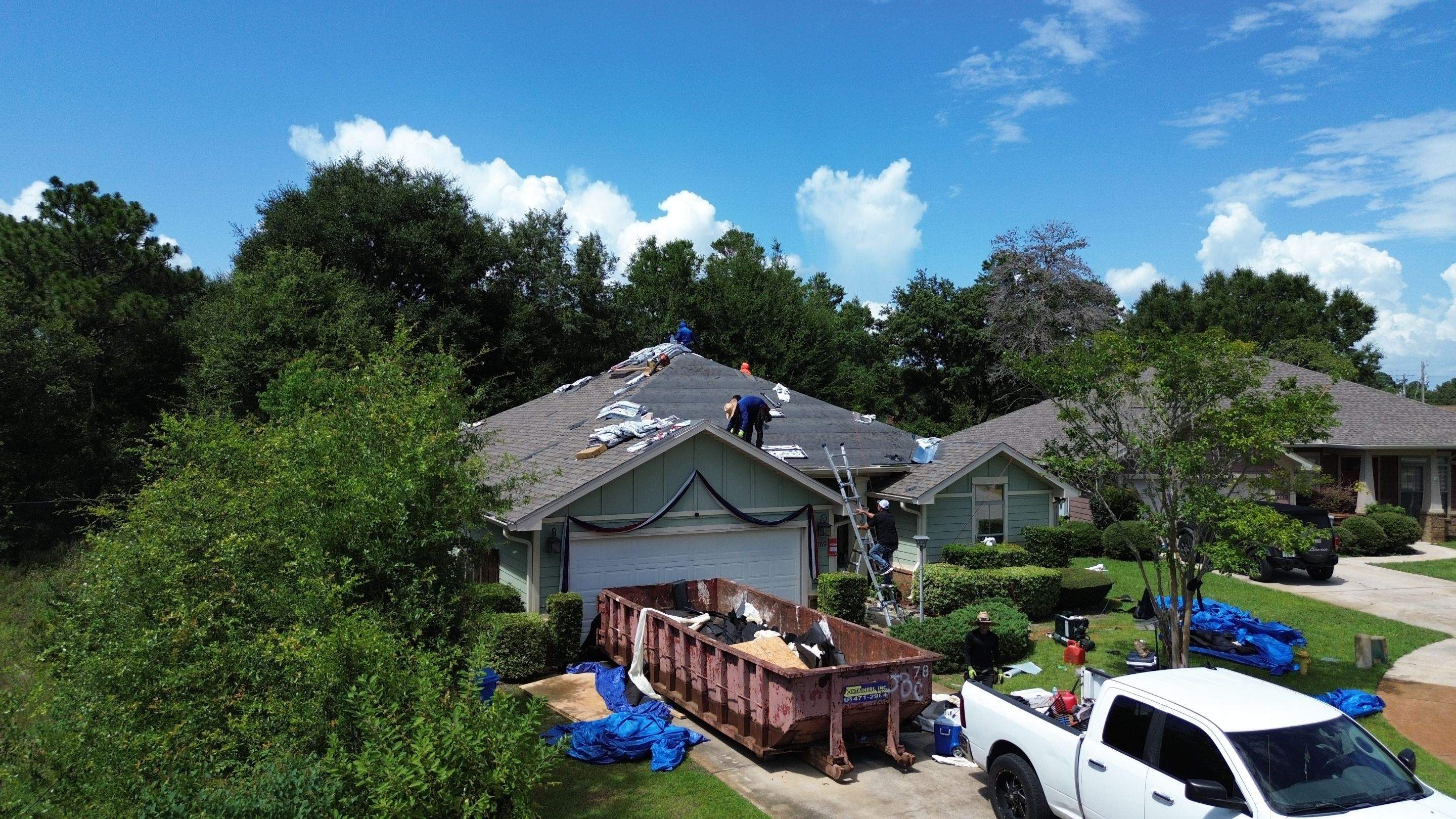 Roofing crew mid-installation on a Northwest Florida home
