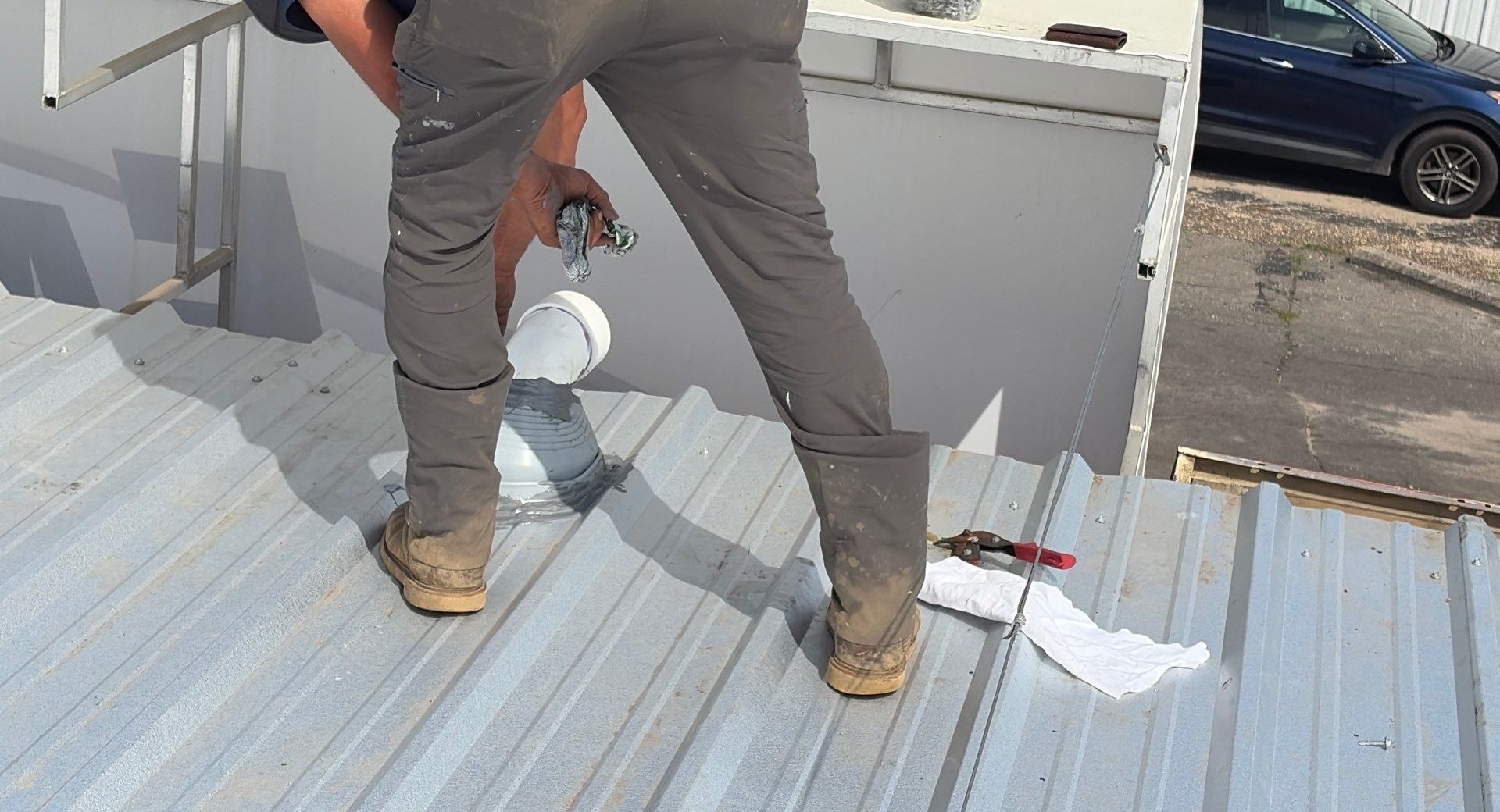 Roofer repairing flashing around a roof penetration