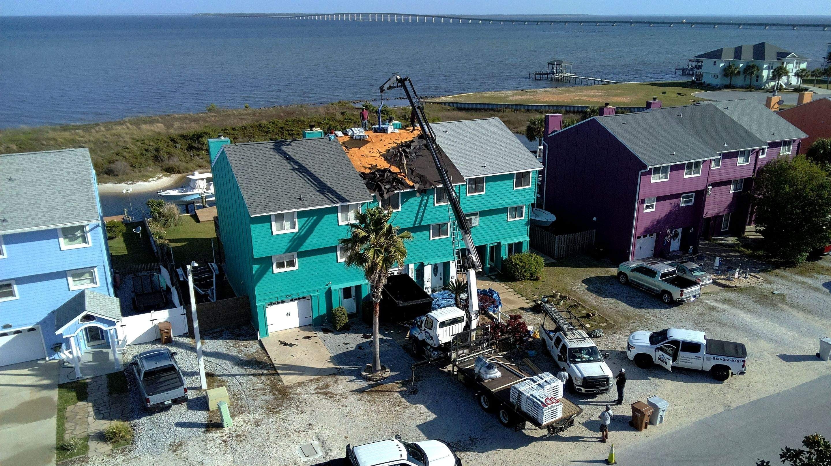 Crane-assisted roof tear-off on a waterfront townhouse