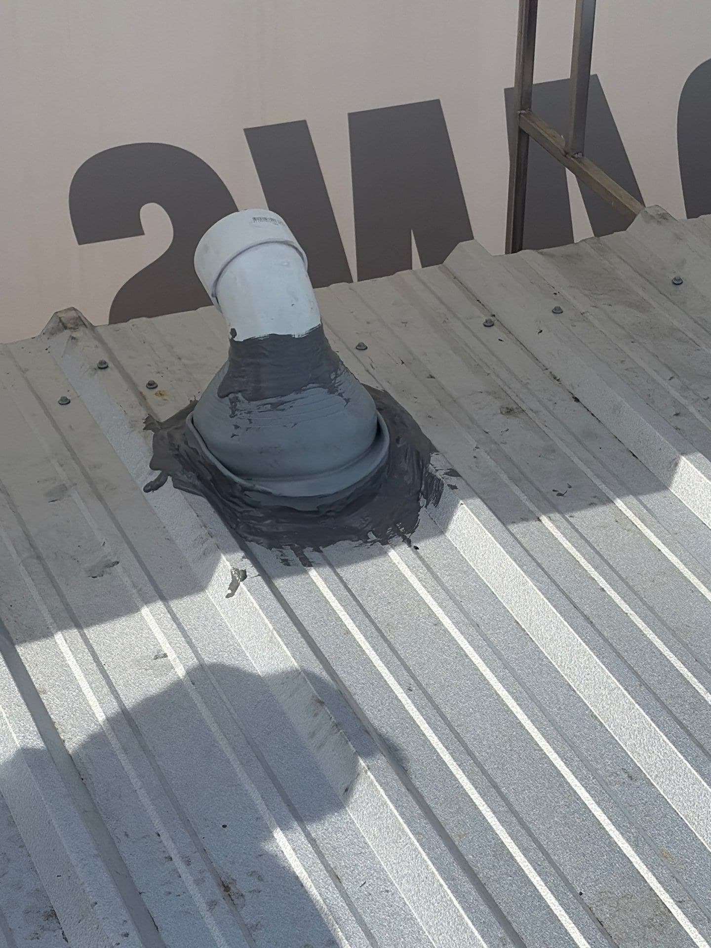 Sealed pipe penetration on a commercial metal roof